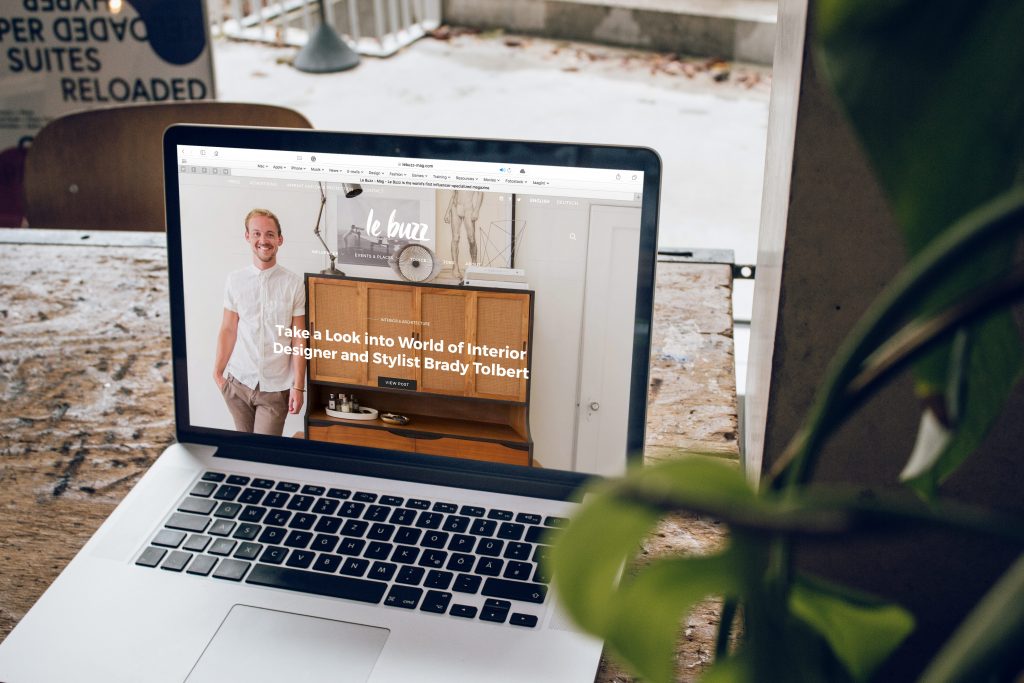 Browsing a Website In MacBook Pro sitting on a restored wooden table | Photo Credit: Le Buzz